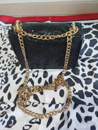 Bolso negro lentejuelas cadena dorada.
