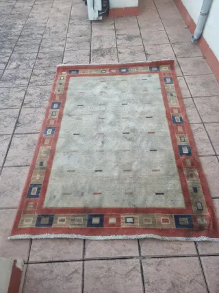 Alfombra beige y roja con diseño geométrico