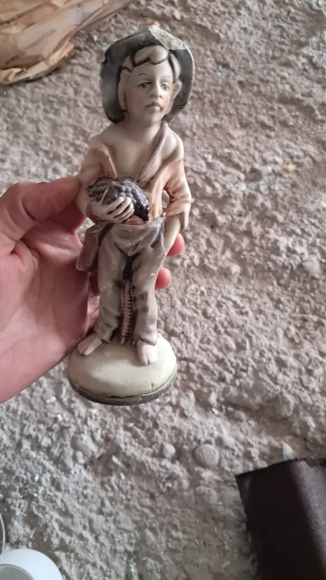 Figura de porcelana niño con uvas.