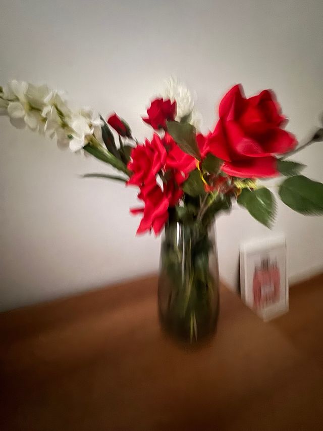 Jarrón de cristal con flores rojas