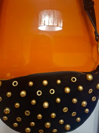 Bandolera ante negro con tachas doradas.