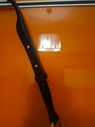 Bandolera ante negro con tachas doradas.