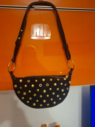 Bandolera ante negro con tachas doradas.