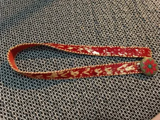 Cinturón rojo con detalles dorados y hebilla