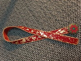 Cinturón rojo con detalles dorados y hebilla