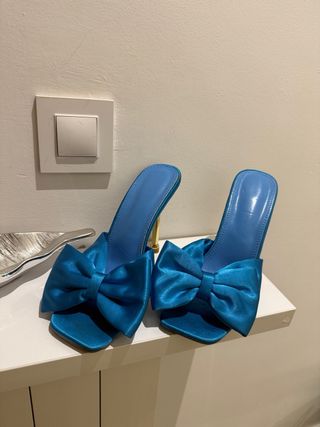 Zapatos de tacón azul con lazo dorado