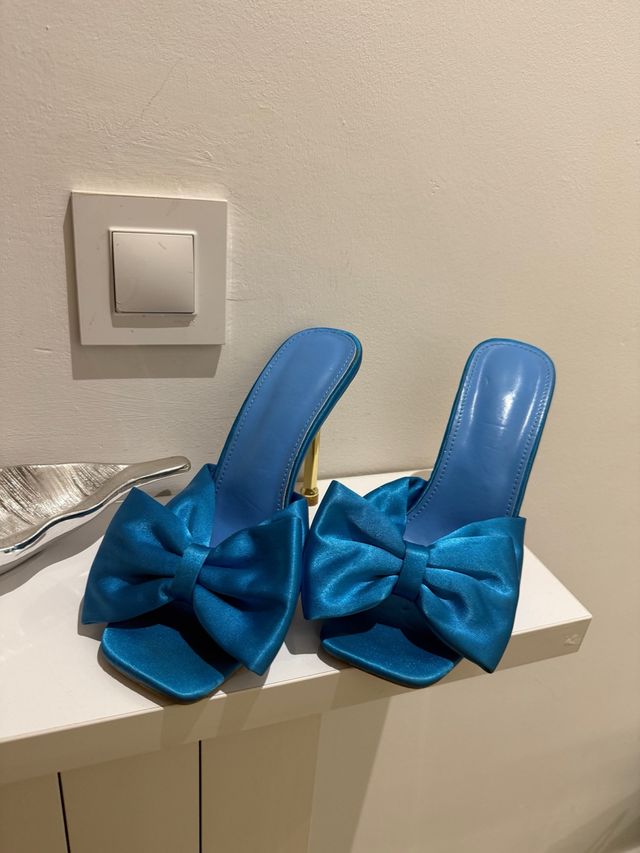 Zapatos de tacón azul con lazo dorado