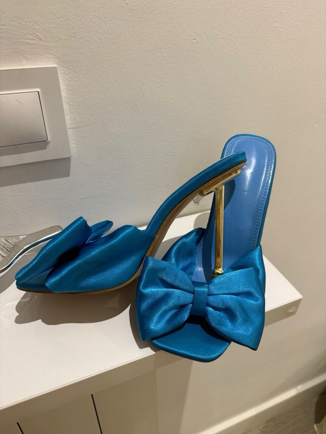 Zapatos de tacón azul con lazo dorado