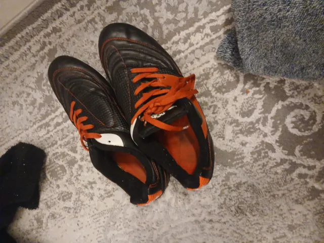 Botas de fútbol negras y naranjas