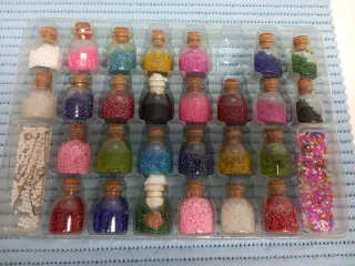 Maletín antiguo con 27  botellitas de perlitas