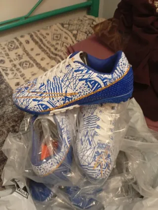 Zapatos de fútbol blancos y azules