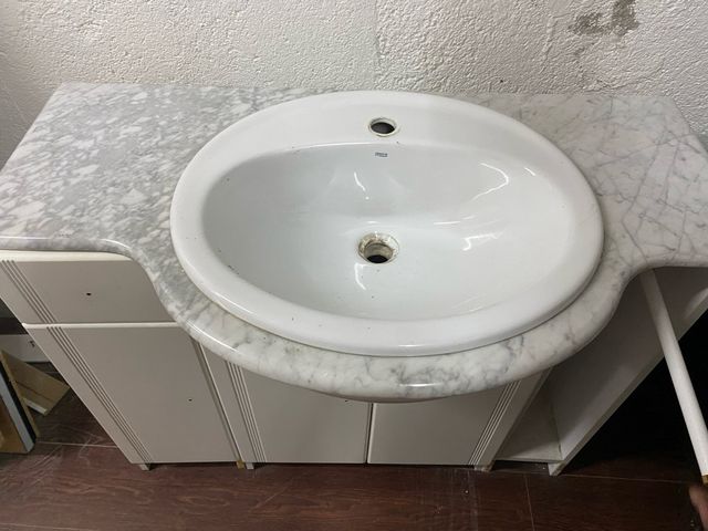 Lavabo Roca con mueble blanco y encimera mármol