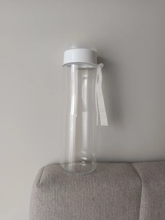 Botella de agua transparente con asa