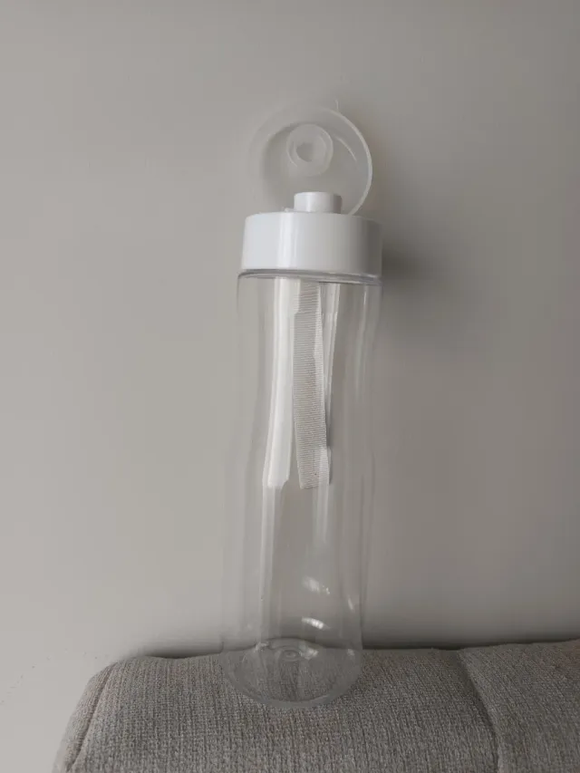 Botella de agua transparente con asa