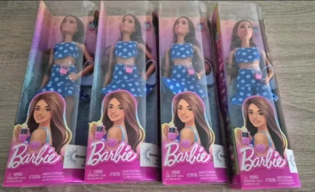 Cuatro muñecas Barbie con traje de lunares.