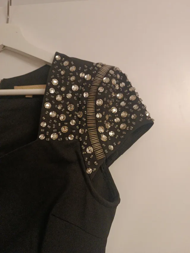 Vestido corto negro con hombreras de pedrería