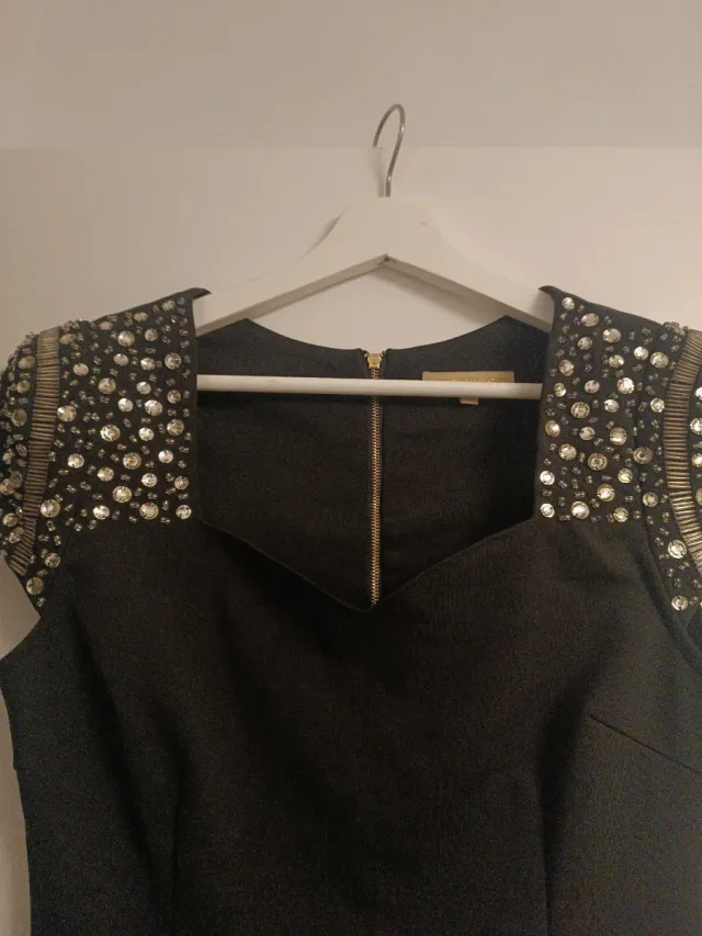 Vestido corto negro con hombreras de pedrería