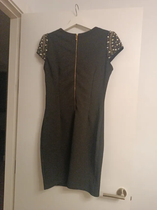 Vestido corto negro con hombreras de pedrería