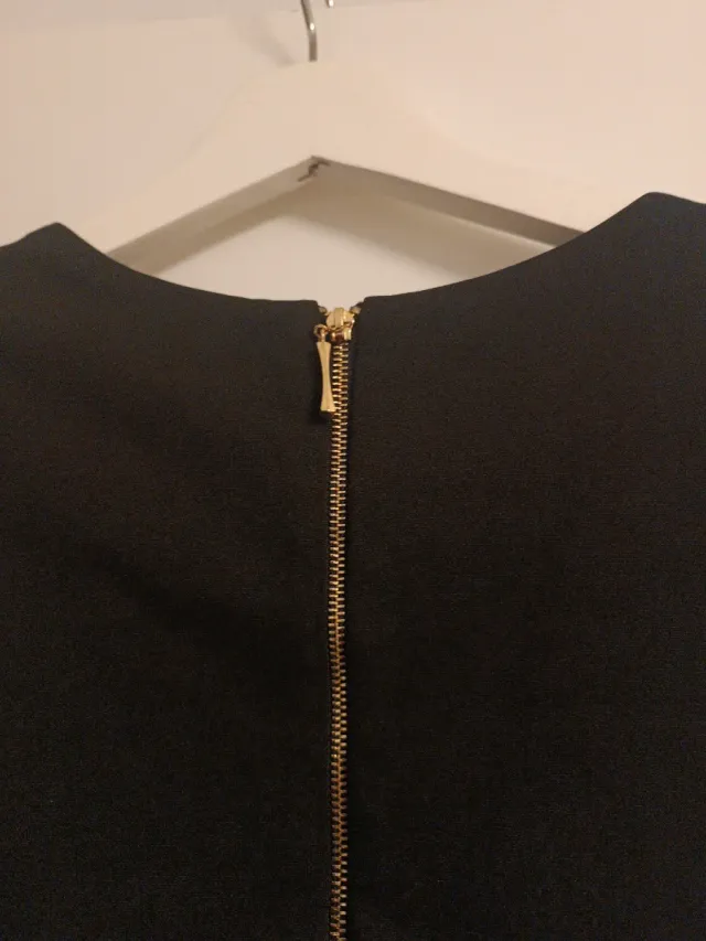 Vestido corto negro con hombreras de pedrería