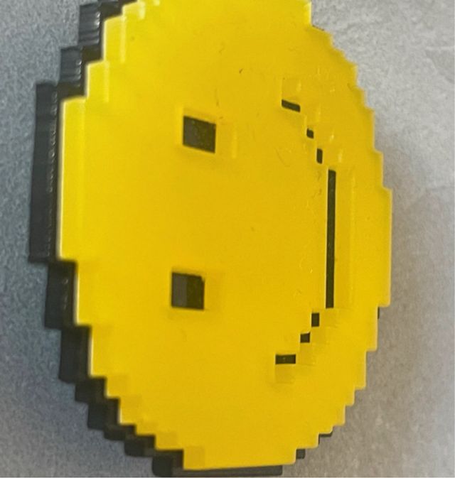 Clip cara pixelada amarilla y negra
