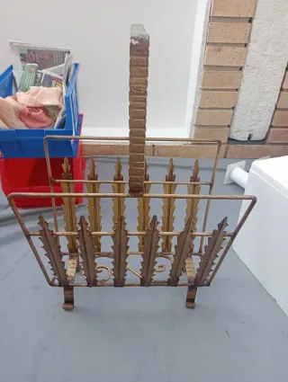 Antiguo revistero de forja dorado.