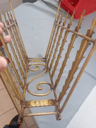 Antiguo revistero de forja dorado.