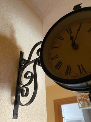 Reloj de pared negro gallo con números romanos.