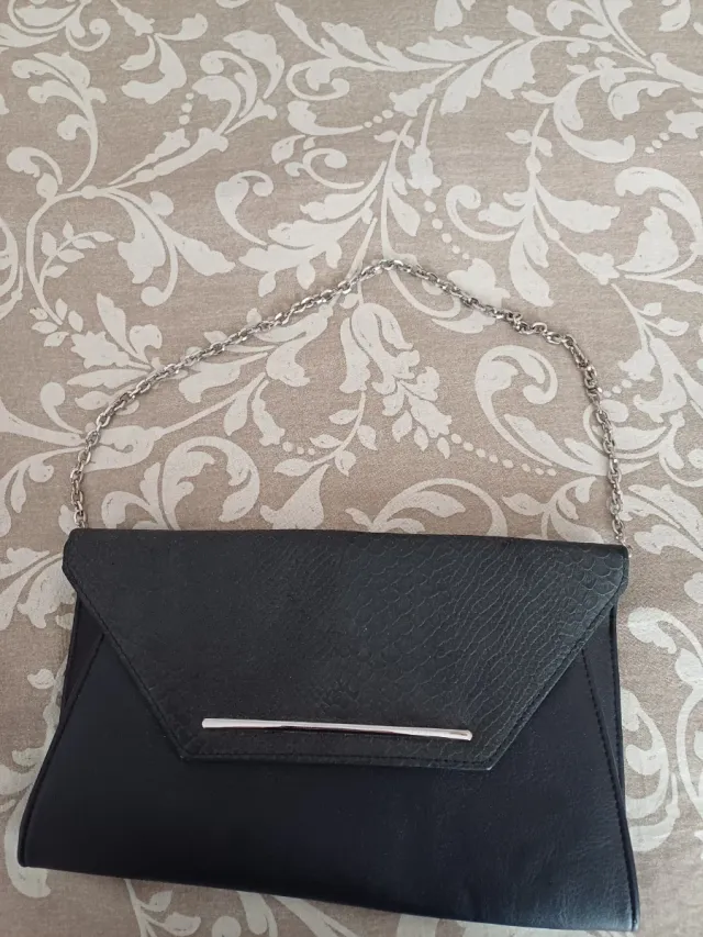 Bolso de mano negro con cadena plateada