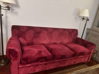 Sofá de terciopelo rojo con cojines de plumas