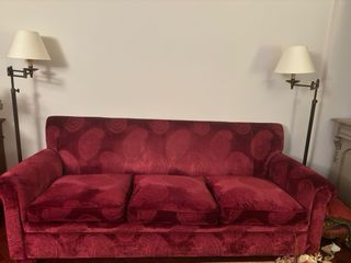 Sofá de terciopelo rojo con cojines de plumas