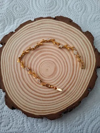 Pulsera dorada con hojas y flores