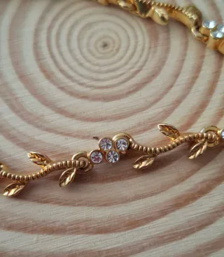 Pulsera dorada con hojas y flores