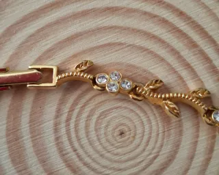 Pulsera dorada con hojas y flores