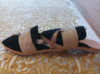 Zapatos planos negros y dorados con flecos