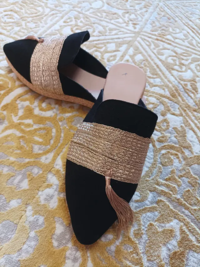 Zapatos planos negros y dorados con flecos