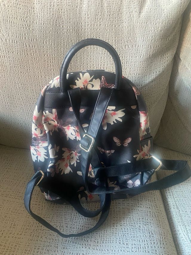 Mochila negra con flores y mariposas