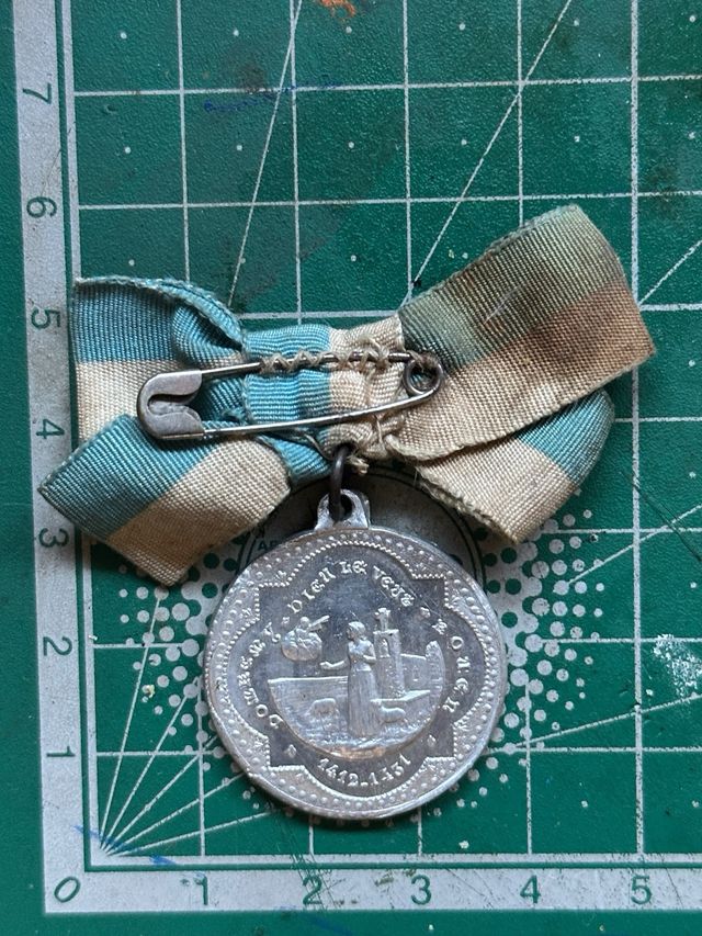 Medalla religiosa antigua con cinta