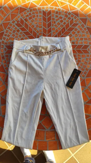 Pantalón blanco estilo cuero con cadena dorada