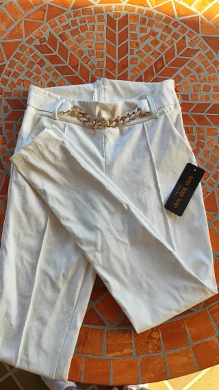 Pantalón blanco estilo cuero con cadena dorada
