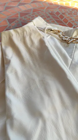 Pantalón blanco estilo cuero con cadena dorada