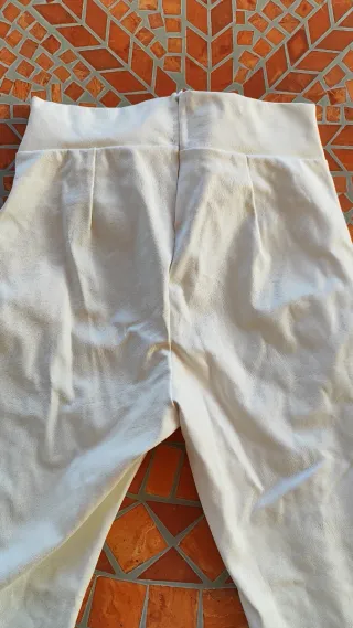 Pantalón blanco estilo cuero con cadena dorada