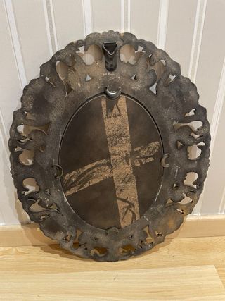 Espejo Ovalado Dorado con marco ornamentado.