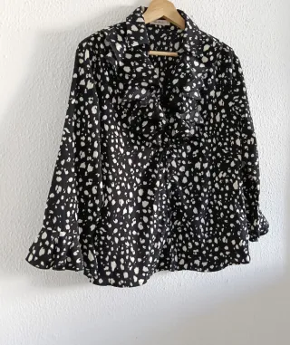 Blusa negra con lunares blancos y volantes.