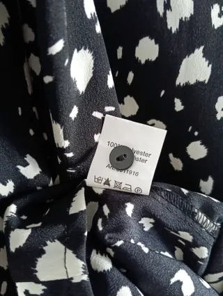 Blusa negra con lunares blancos y volantes.