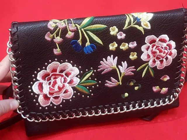 Bolso de mano negro con flores bordadas