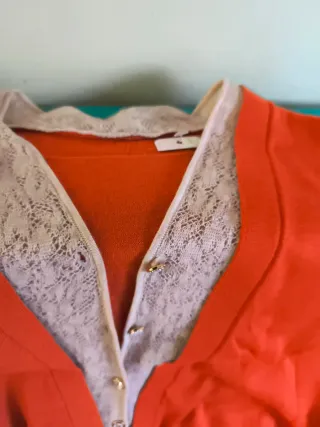 Blusa naranja con encaje blanco