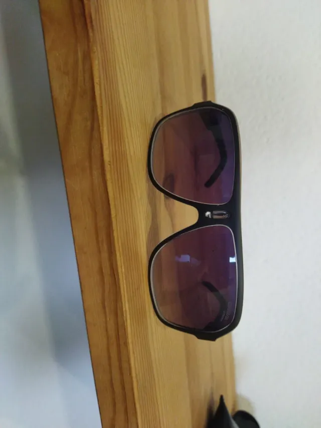 Gafas de sol Carrera negras y moradas en mano