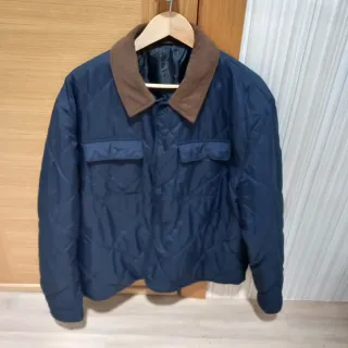 Cazadora acolchada hombre azul y cuello marrón.