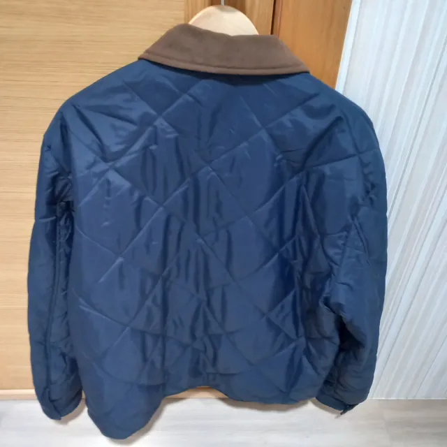 Cazadora acolchada hombre azul y cuello marrón.