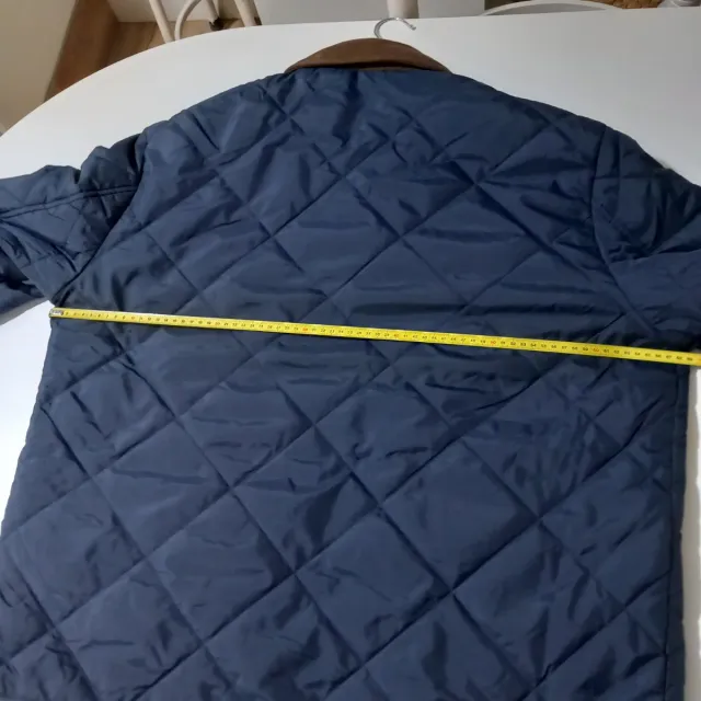 Cazadora acolchada hombre azul y cuello marrón.